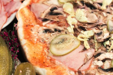 Jambonlu İtalyan pizzası, salatalık ve mantar. Sığ alan derinliği.