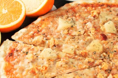 Egzotik meyveli pizza ve yakın plan tavuk. Sığ alan derinliği