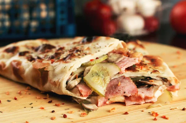 Tasty pizza rolls closed pizza calzone with ham, mushrooms and cucumber. Shallow depth of field
