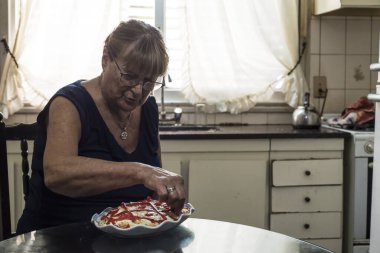 Yaşlı kadın günlerini karantinada patates salatası ve biberli mayonez pişirerek geçiriyor.