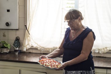 Yaşlı kadın günlerini karantinada patates salatası ve biberli mayonez pişirerek geçiriyor.