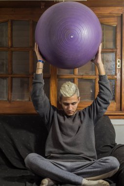 Coronavirus tarafından karantinaya alınan genç adam evde meditasyon ve rahatlama yoluyla akıl sağlığını güçlendiriyor.