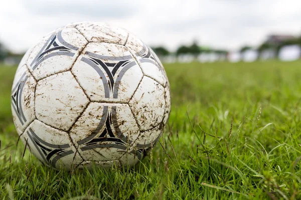 Bir futbol sahası üzerinde çamurlu futbol topu.