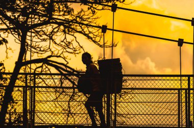 3 Ağustos 2014 'te, Doğu Java, Endonezya' da, Ponorogo 'daki asma köprüde yürüyen bir kadın görülüyor.