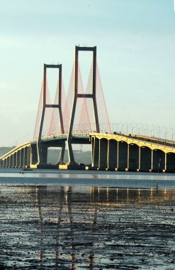 Suramadu Köprüsü, Madura Boğazı 'nda güneş batmadan önce öğleden sonra ışıklarıyla uzanır. Endonezya 'daki en uzun köprüdür..