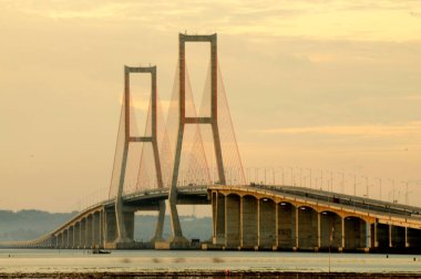 Suramadu Köprüsü, Madura Boğazı 'nda güneş batmadan önce öğleden sonra ışıklarıyla uzanır. Endonezya 'daki en uzun köprüdür..