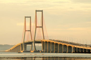 Suramadu Köprüsü, Madura Boğazı 'nda güneş batmadan önce öğleden sonra ışıklarıyla uzanır. Endonezya 'daki en uzun köprüdür..