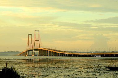 Suramadu Köprüsü, Madura Boğazı 'nda güneş batmadan önce öğleden sonra ışıklarıyla uzanır. Endonezya 'daki en uzun köprüdür..