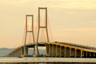 Suramadu Köprüsü, Madura Boğazı 'nda güneş batmadan önce öğleden sonra ışıklarıyla uzanır. Endonezya 'daki en uzun köprüdür..
