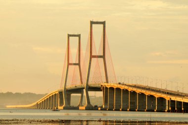 Suramadu Köprüsü, Madura Boğazı 'nda güneş batmadan önce öğleden sonra ışıklarıyla uzanır. Endonezya 'daki en uzun köprüdür..