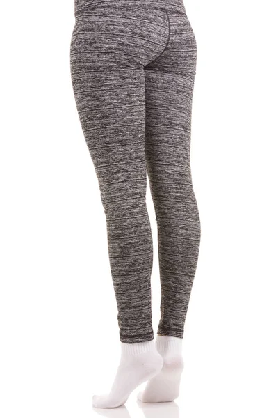 Achteraanzicht van fit vrouw benen in witte sokken permanent op tenen in grijs patroon thermische broek — Stockfoto