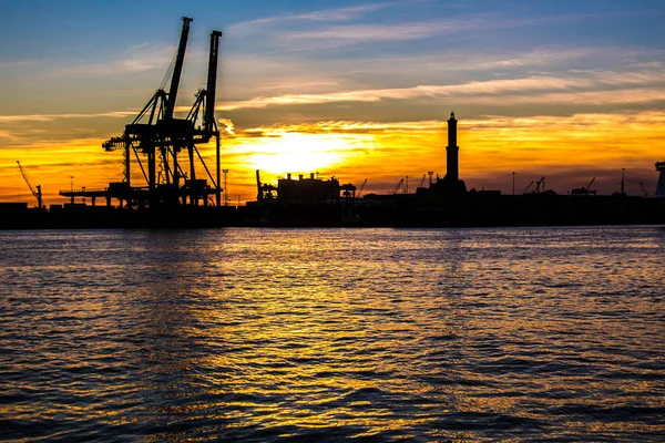 sunset at Genoa's port, silhouette of the Lanterna: the main lighthouse and symbol of the city, in Italy
