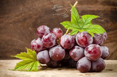 ahşap arka plan üzerinde kırmızı üzüm