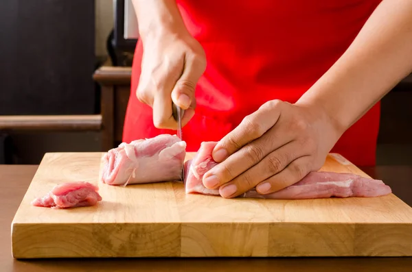 Koch schneidet rohes Schweinefleisch — Stockfoto