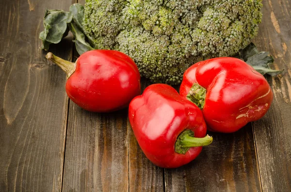 Poivrons rouges et brocoli sur fond de bois — Photo