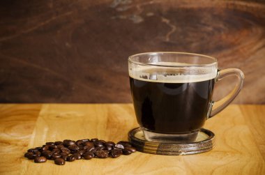 Ahşap zemin üzerine kavrulmuş kahve çekirdeği ile sıcak kahve