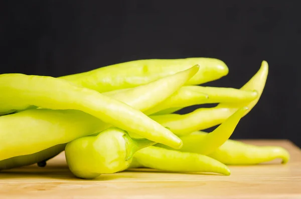 Zelené chilli papričky na dřevěné desce, potraviny — Stock fotografie