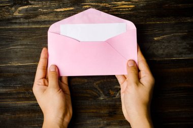 Pembe zarf ve elle tutarak boş beyaz kartı