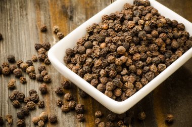 Ahşap arka plan üzerinde kuru kara biber