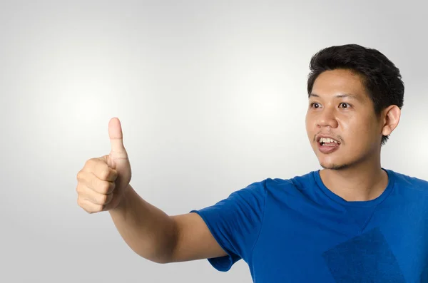 Asijské muži ukazují palec nahoru izolované na šedém pozadí — Stock fotografie