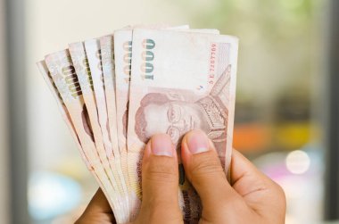 1000 Tayland Bahtı banknot tutan el