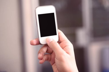 Boş ekranlı akıllı telefonu tutan el.