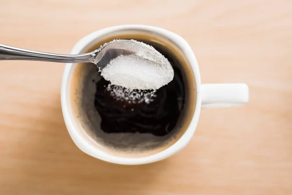 Despejar açúcar em xícara de café — Fotografia de Stock