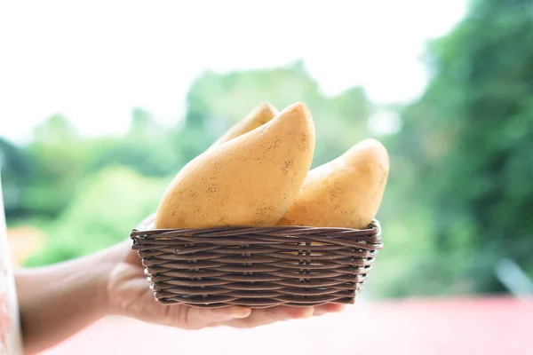 Reife Mangofrüchte in Korb mit der Hand halten — Stockfoto
