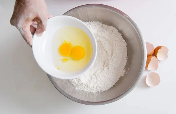 Hand gießen Eigelb mit Mehl vermischen, um Brot zu machen — Stockfoto