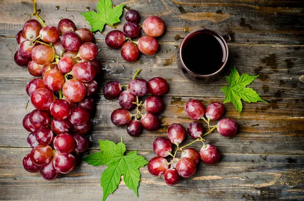 Red grapes and juice on wooden background — Stock Photo, Image