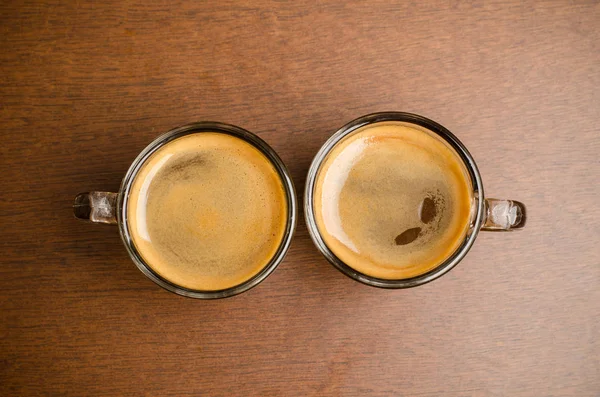 两杯热咖啡在咖啡厅喝杯木制的桌子上 — 图库照片