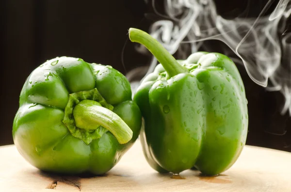 Groene paprika met rook op zwarte achtergrond — Stockfoto