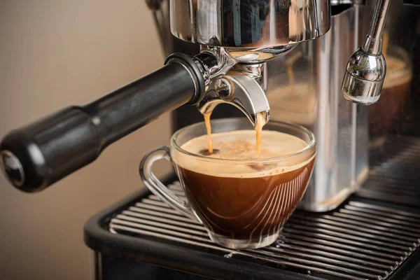 Nybryggt kaffe rinner till en kopp från espressomaskin — Stockfoto