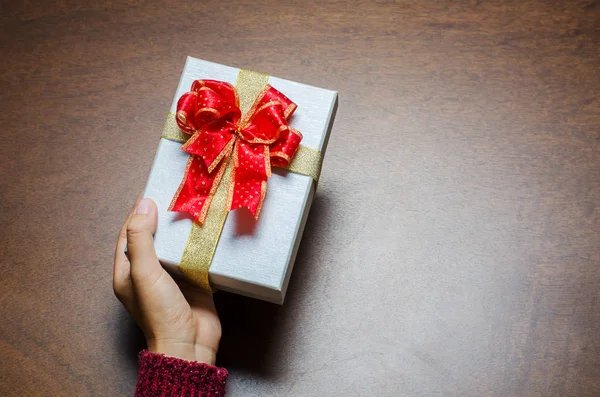 Mujer sosteniendo caja de regalo a mano para dar en días festivos — Foto de Stock