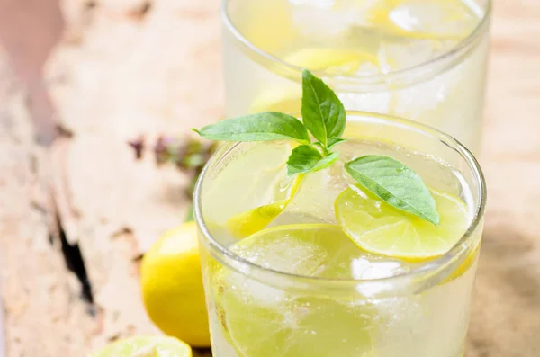 Холодный лимонад со льдом и свежим ломтиком лимона в стакане — стоковое фото