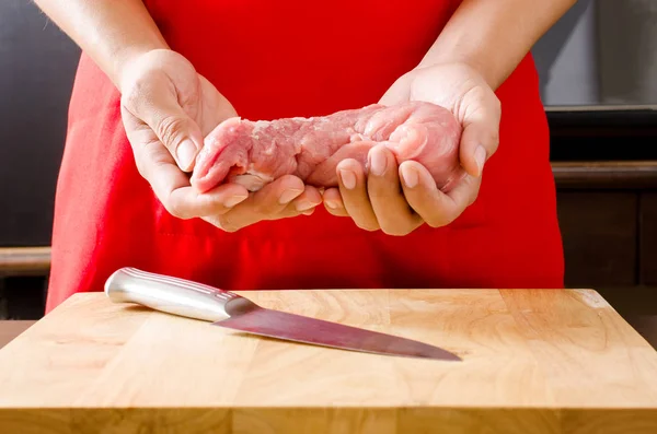 Рука тримає сиру свинину, приготовану для приготування їжі — стокове фото
