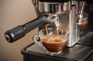 Taze kahve bir fincan espresso makinesi üzerinden akan