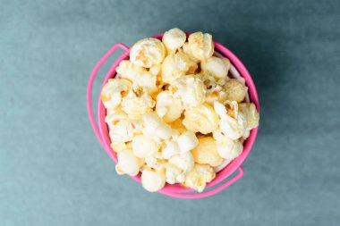 Pembe bir kova, üstten görünüm karamelli patlamış mısır