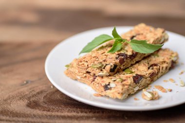 Snack bar veya enerji bar beyaz tabak ve ahşap arka plan