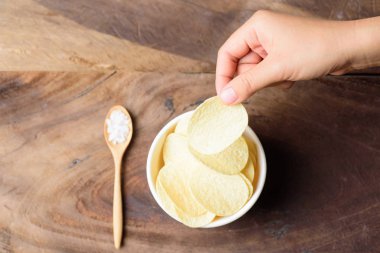 Patates cipsi bir kase ve beslenme, en iyi görünümü tutan el