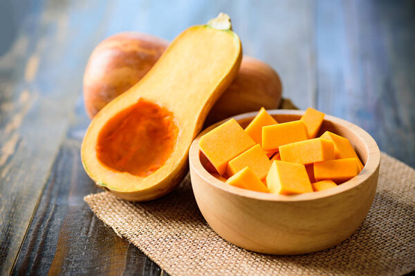 Sliced butternut squash in a bowl for cooking on wooden background