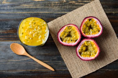 Bir bardak tutku meyvesi suyu ve ahşap arka planda taze tutku meyvesi, tropikal meyve, üst manzara.