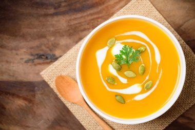 Kabak tohumlu kabak ezmesi çorbası ve ahşap arka planda krema.