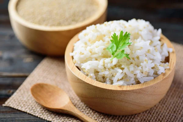 Bowl of cooked rice with quinoa seed and raw quinoa seed on wooden background, healthy food