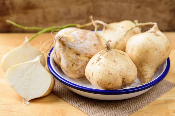 Jicama (Meksika yer elması fasulyesi veya Meksika turpu) ahşap arka planda.