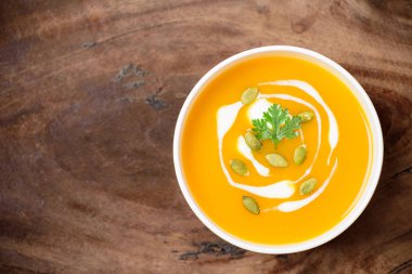 Kabak tohumlu kabak ezmesi çorbası ve ahşap arka planda krema.