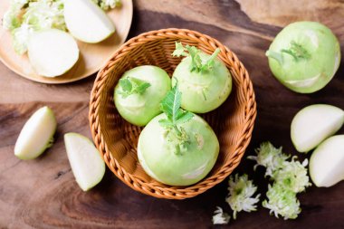 Ahşap arka planda sepetteki taze kohlrabi, üst manzara.