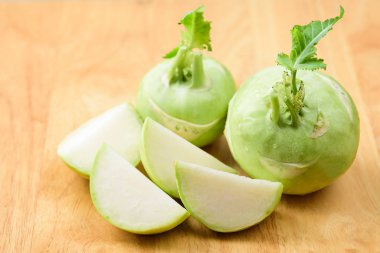 Ahşap arka planda taze dilimlenmiş kohlrabi, organik sebze.