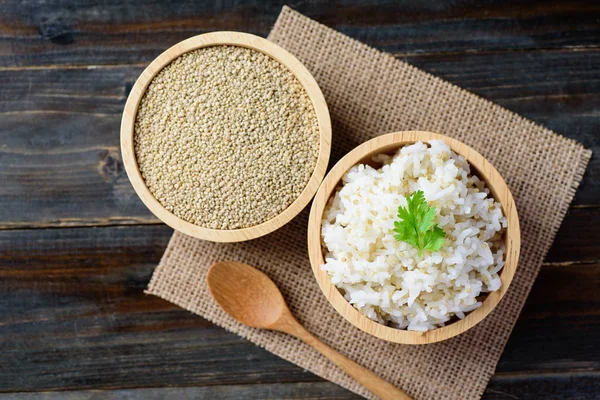 Cooked rice with quinoa seed in bowl on wooden background, healthy food, top view