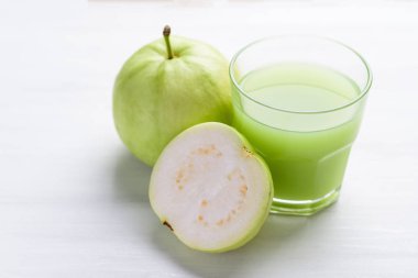 Beyaz arka planda yeşil guava meyvesi ve guava suyu, yüksek C vitamini sağlıklı içecek.